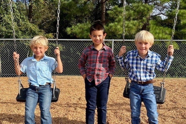 male students on playground swings